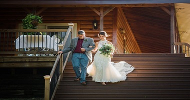 Father walking Bride down Lodge stairs to Gazebo for wedding at Three Falls Cove